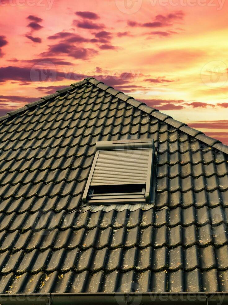 Open roof window in velux style with black roof tiles. photo