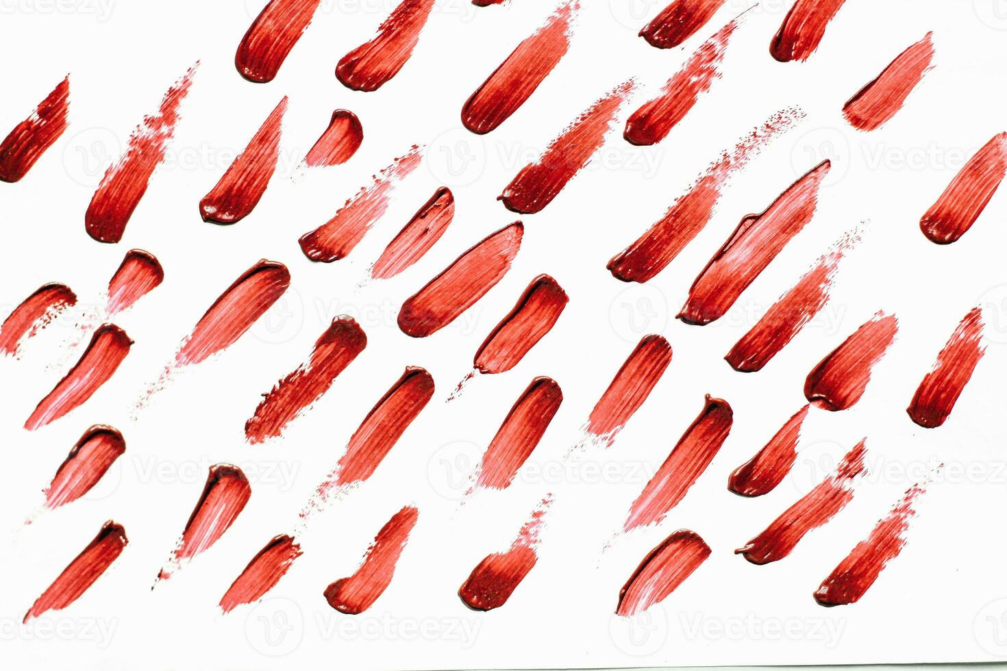 Smears of red cosmetic lipstick on a light background photo