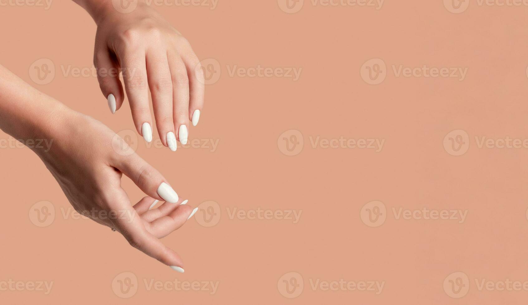 Hands of a beautiful well-groomed woman with feminine nails on a beige background. Manicure photo