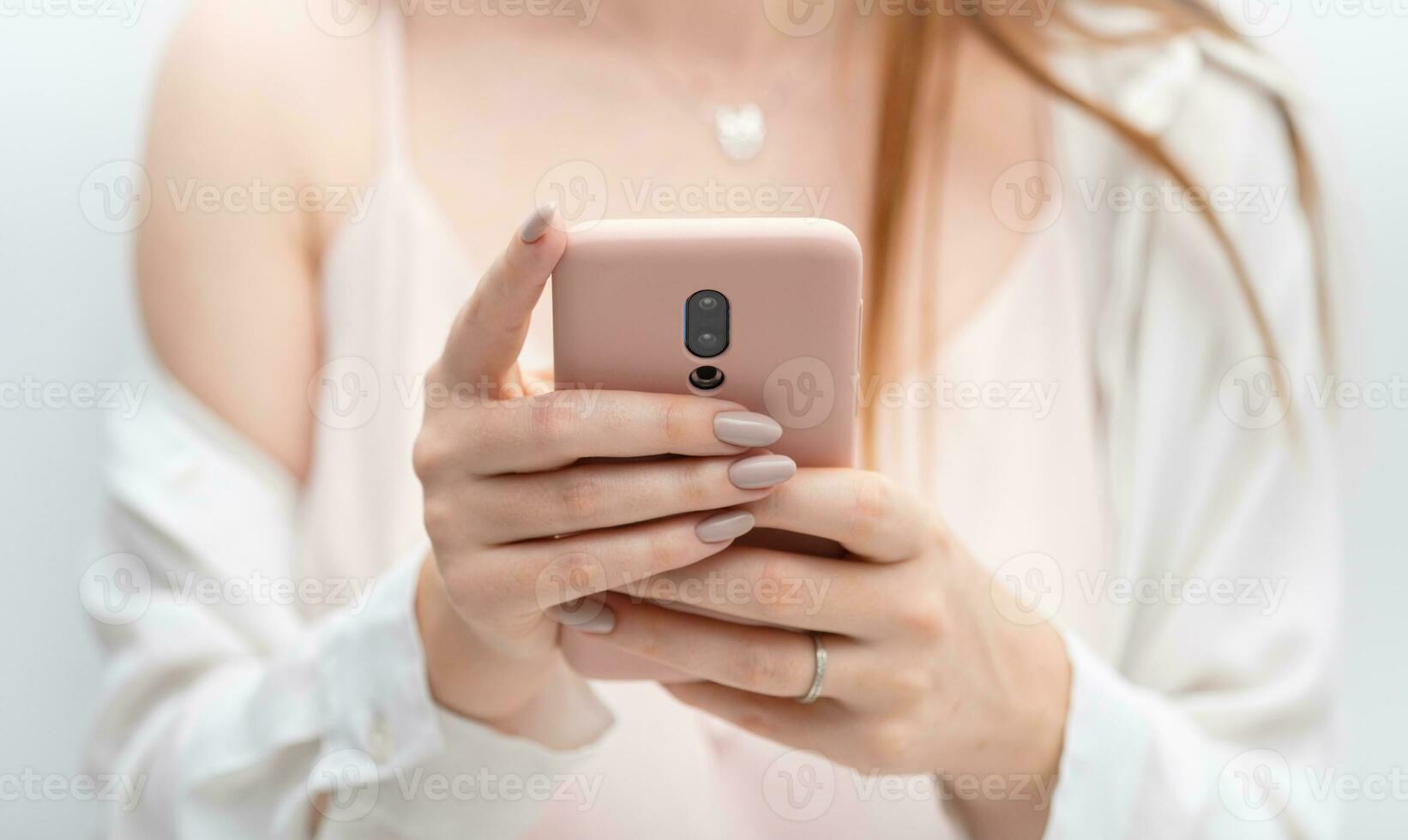 Female hands young woman using pink case smart phone photo