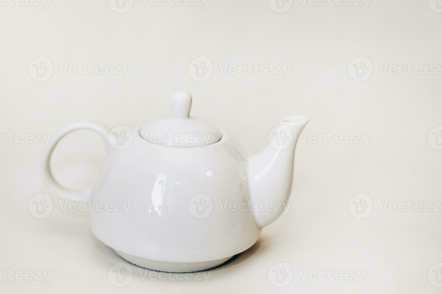White ceramic teapot infuser on white background photo