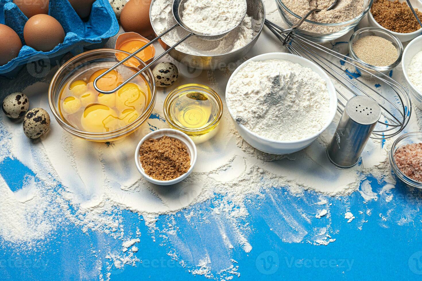 Baking ingredients on blue color background, top view photo