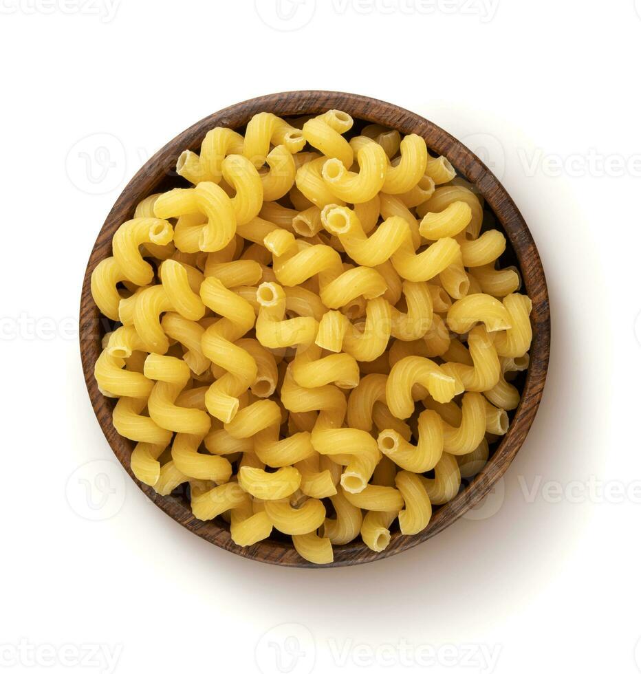 Cellentani pasta in wooden bowl isolated on white background, top view photo