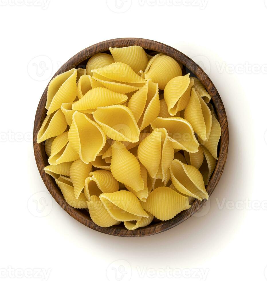 Conchiglie rigate pasta in wooden bowl isolated on white background, top view photo