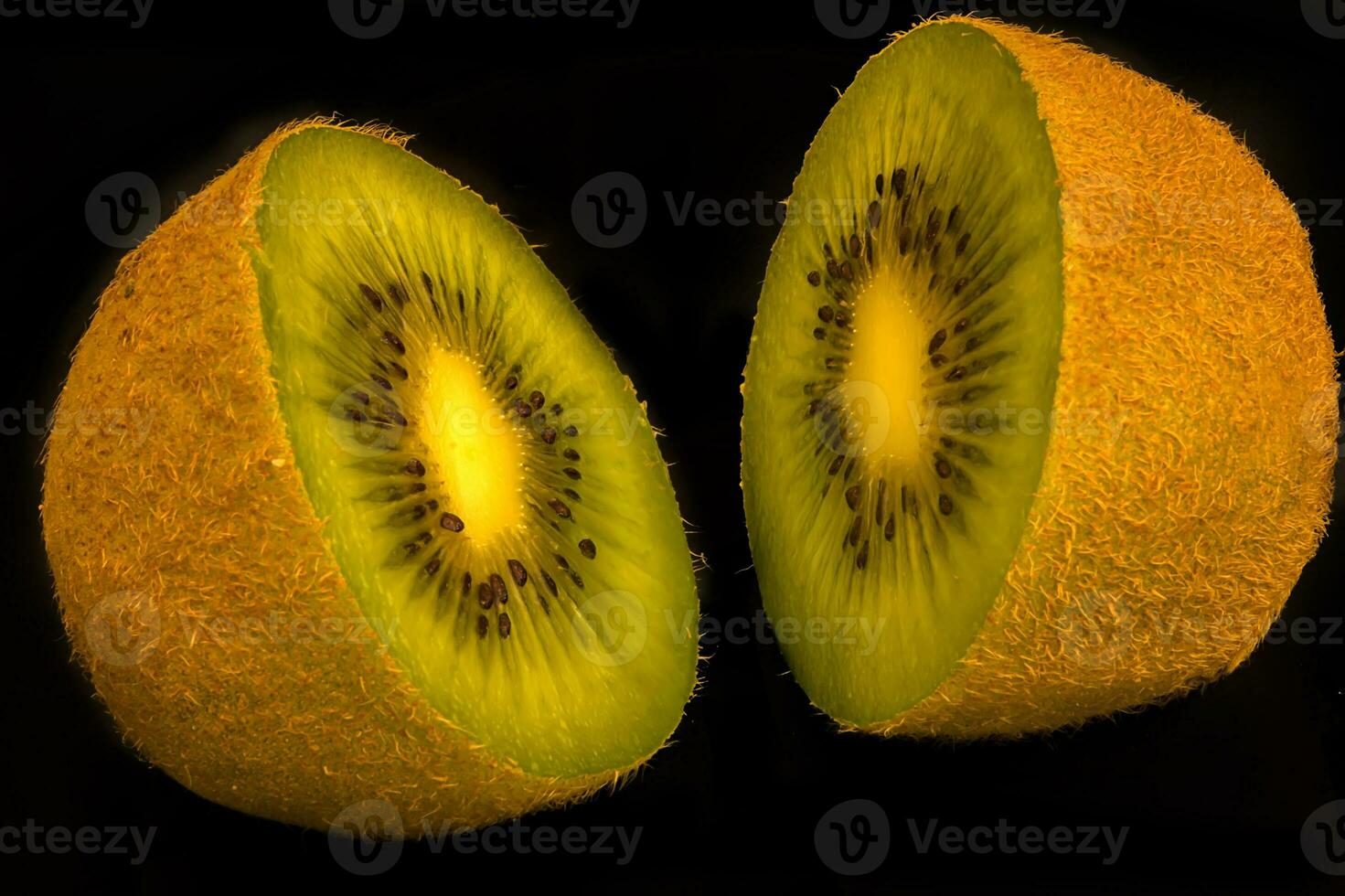 Kiwi fruit cut into halves shot against a black background. photo