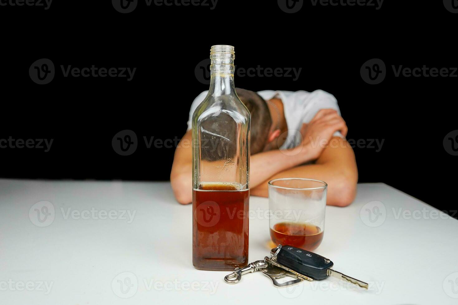 Car keys and alcohol on the table. Drunk man sleeping on the table with bottle of whiskey and drink. Alcoholism. Don't drive when you're drunk. photo