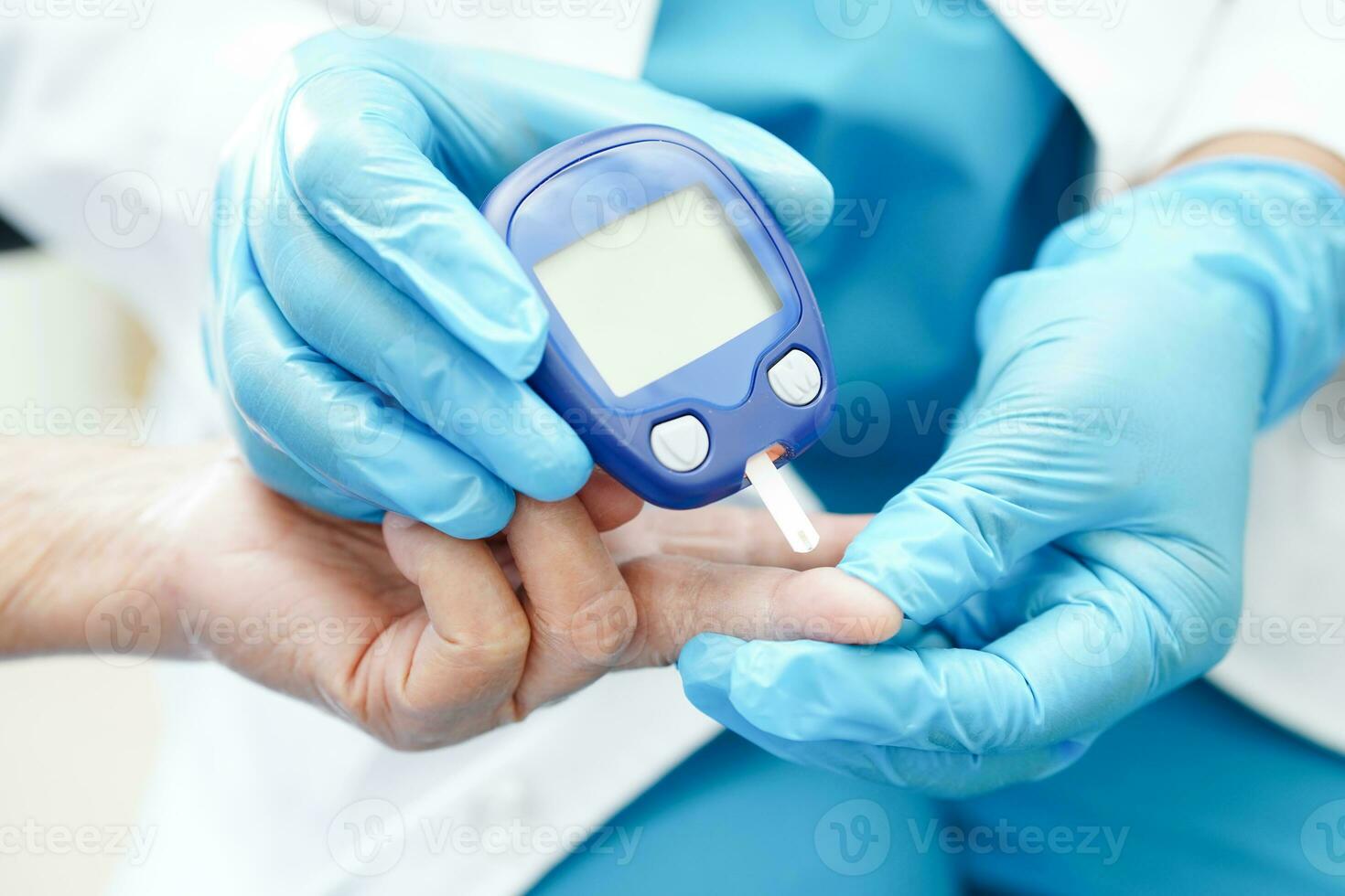 Asian doctor using digital glucose meter for check sample blood sugar level to treatment diabetes. photo