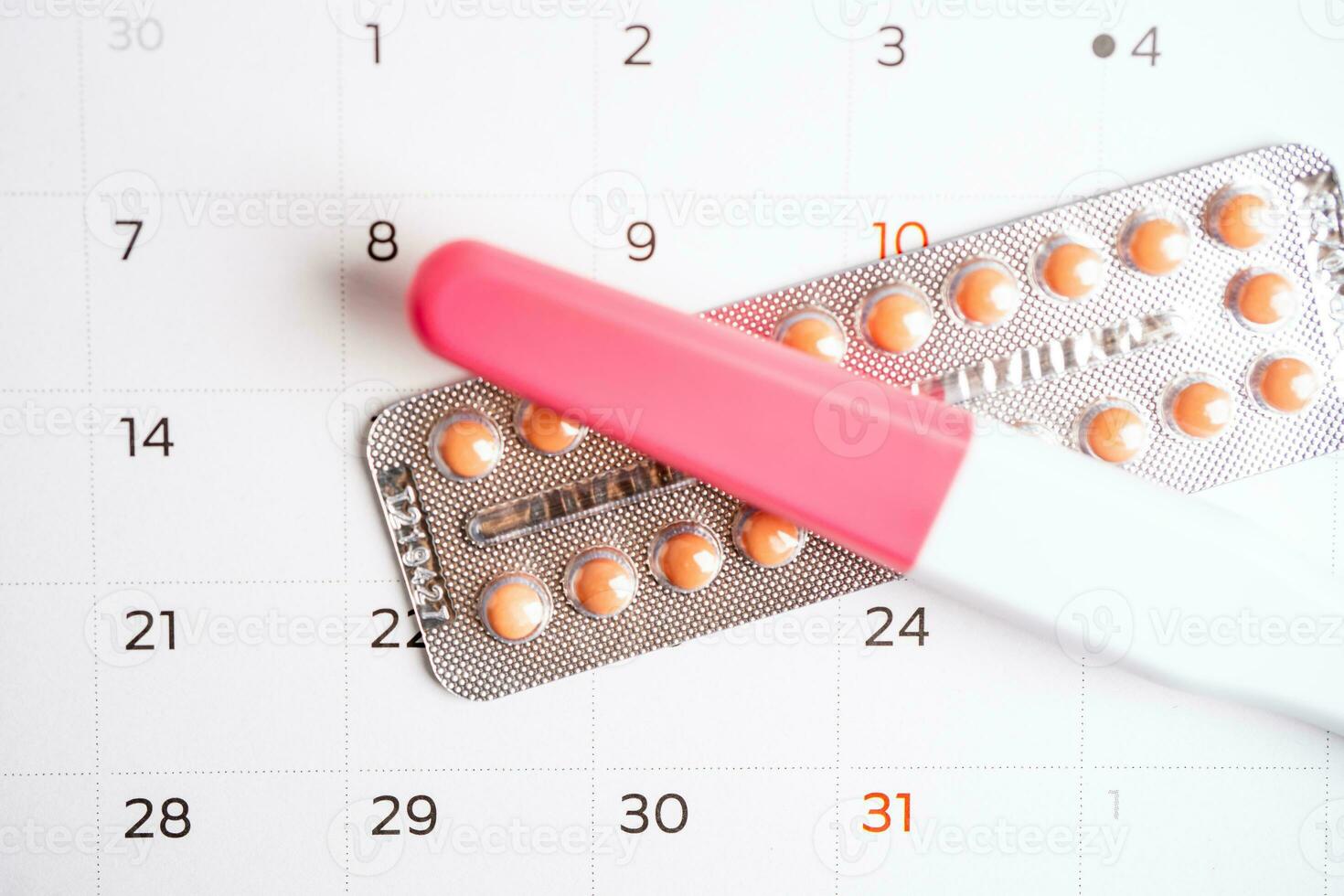 Pregnancy test and birth control pills on calendar, contraception health and medicine. photo