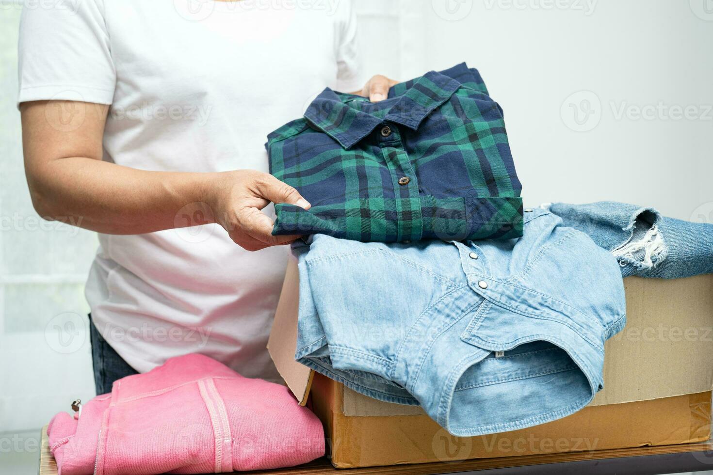 Donation box with used clothes at home to support help for poor people in the world. photo