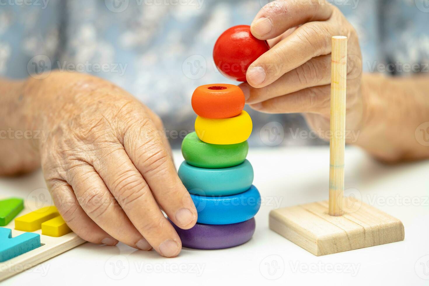 Alzheimer disease AD, Asian elderly woman patient suffering from dementia learn practical motor skills rehabilitation. photo