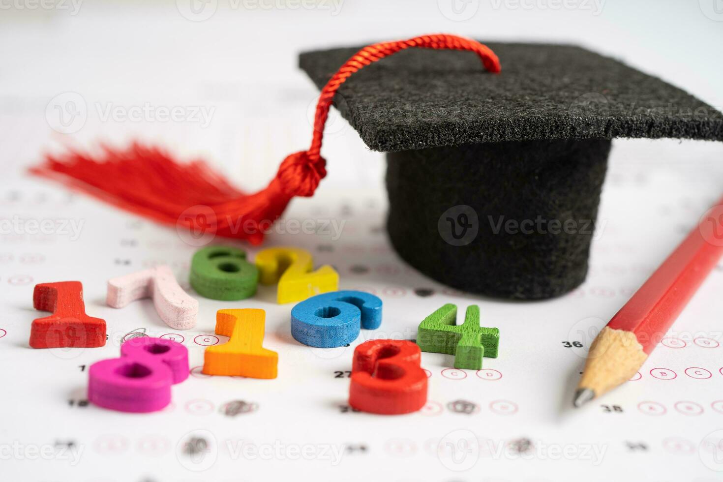 Graduation gap hat and pencil on answer sheet paper, Education study testing learning teach concept. photo