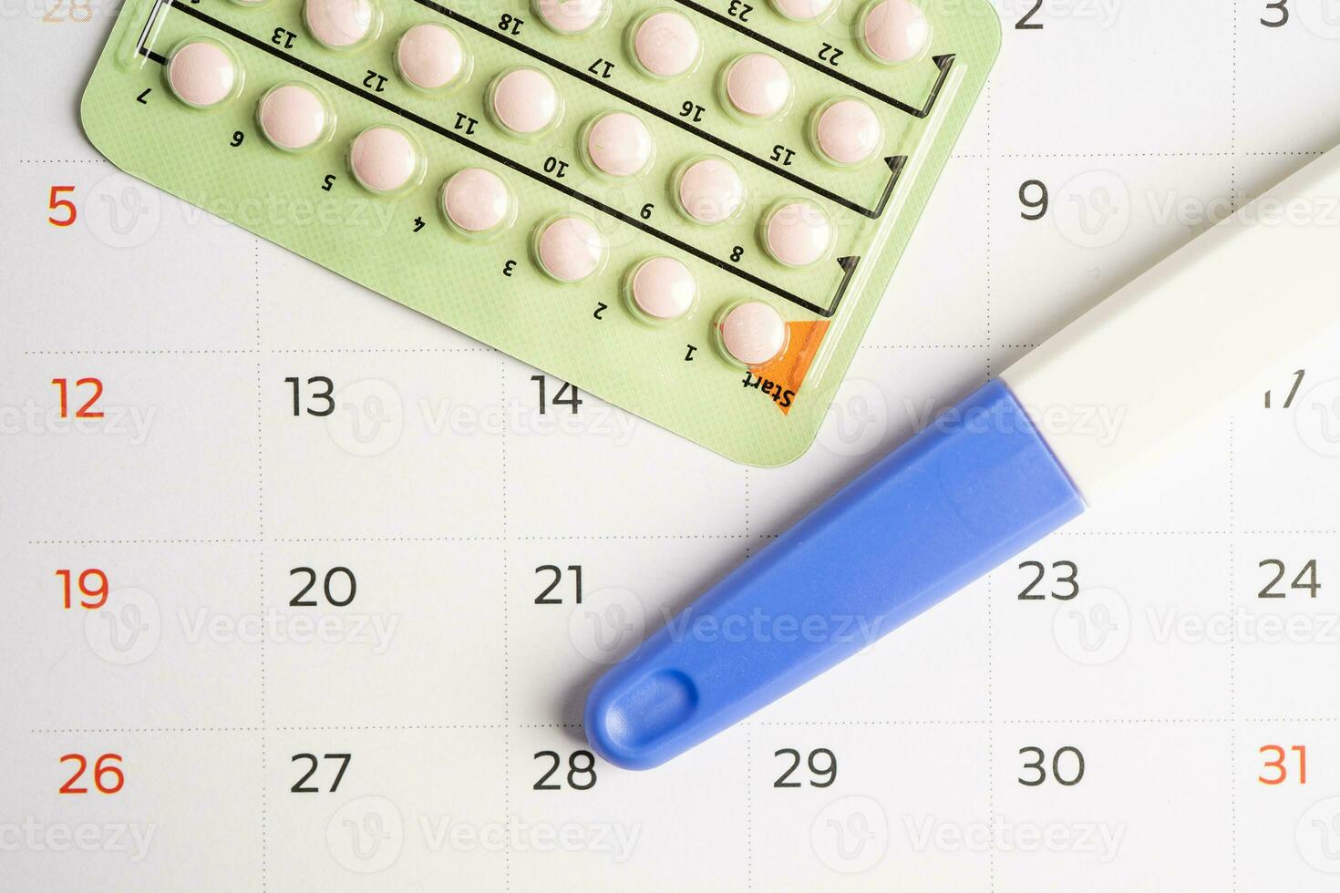 Pregnancy test and birth control pills on calendar, contraception health and medicine. photo