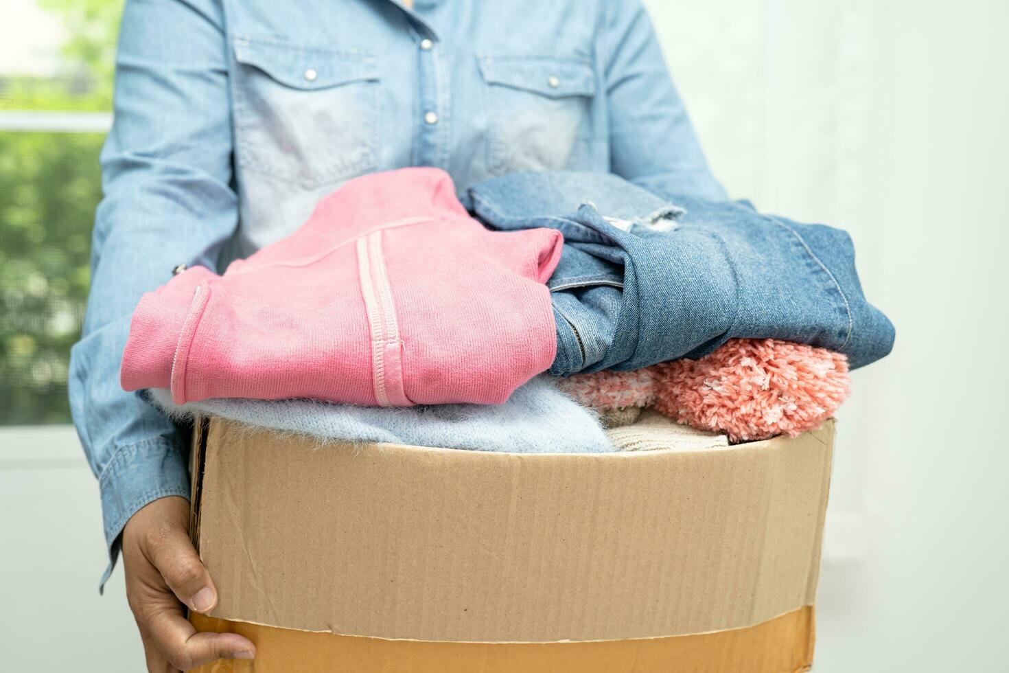 Donation box with used clothes at home to support help for poor people in the world. photo