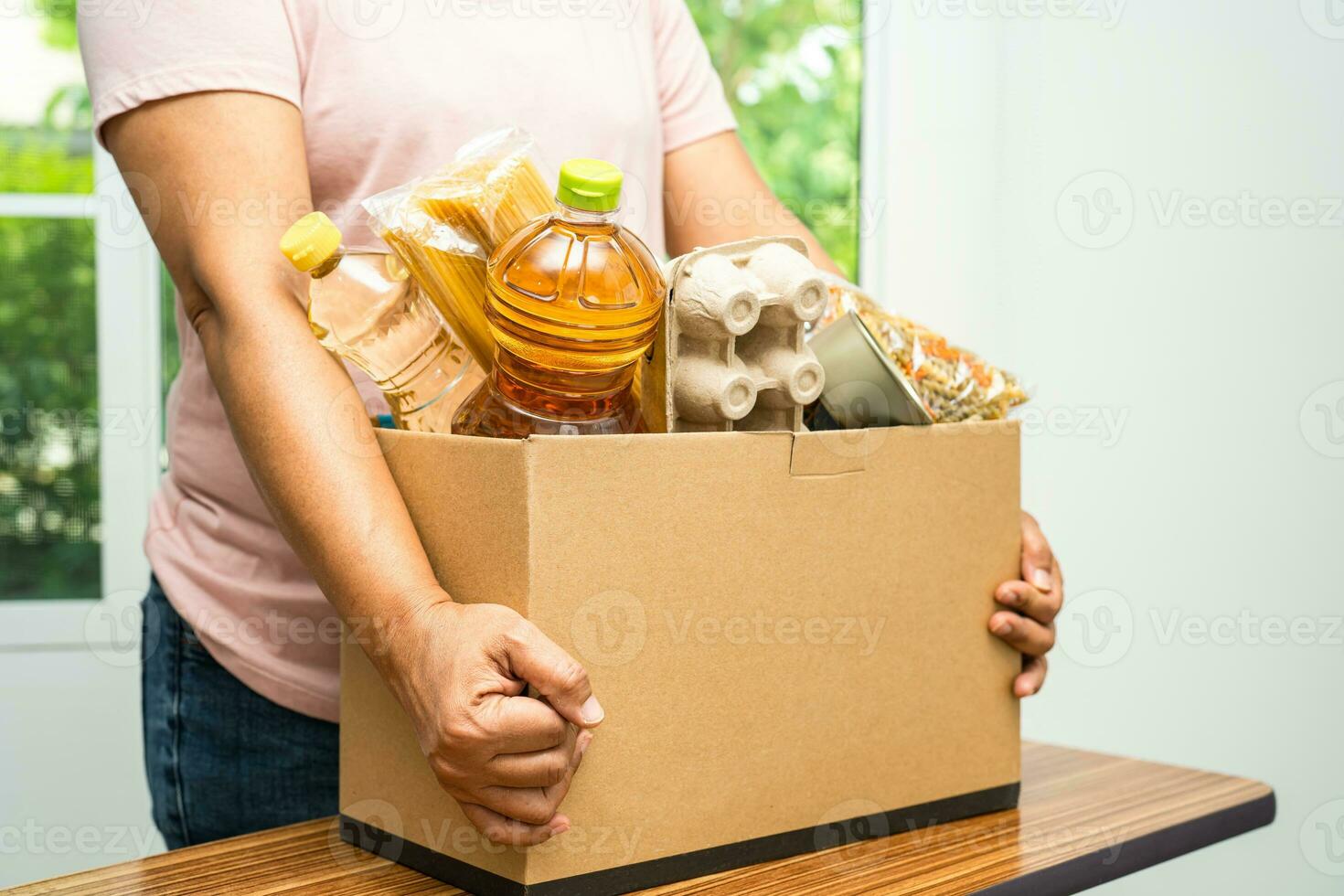 Volunteers putting various dry food in donation box for help people. photo