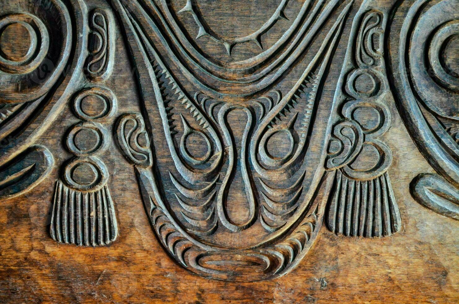 carved wood panel with tribal designs photo