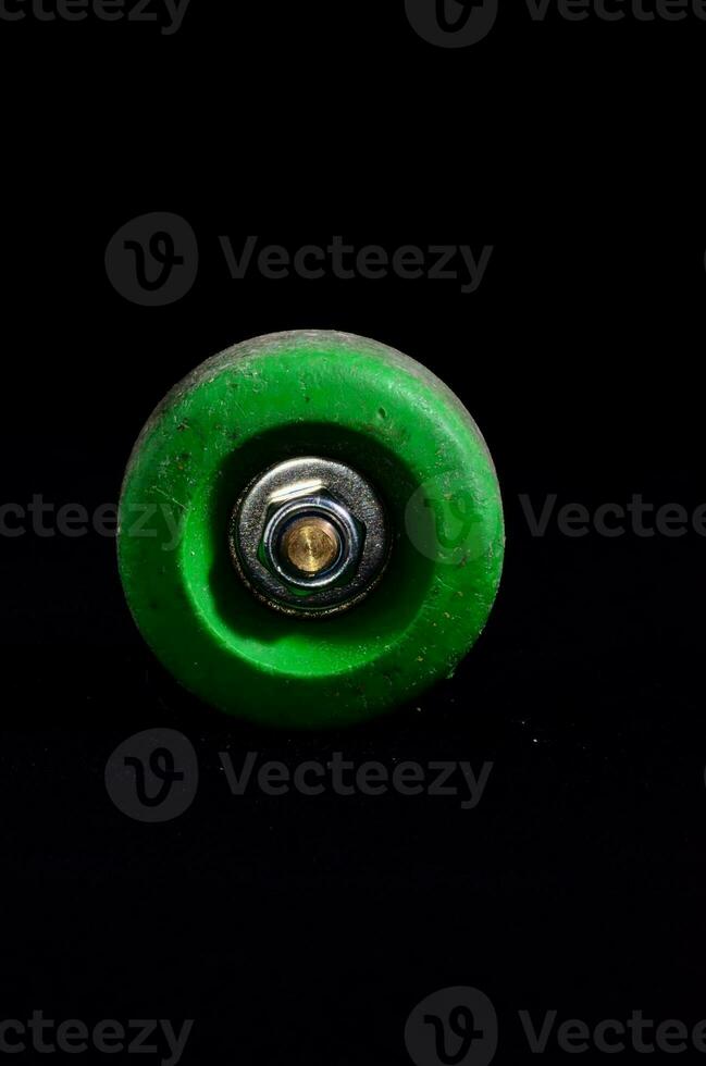 a green skateboard wheel on a black background photo
