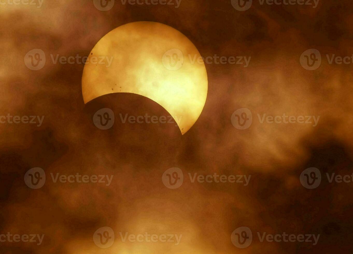 el Dom es visto mediante el nubes durante un solar eclipse foto