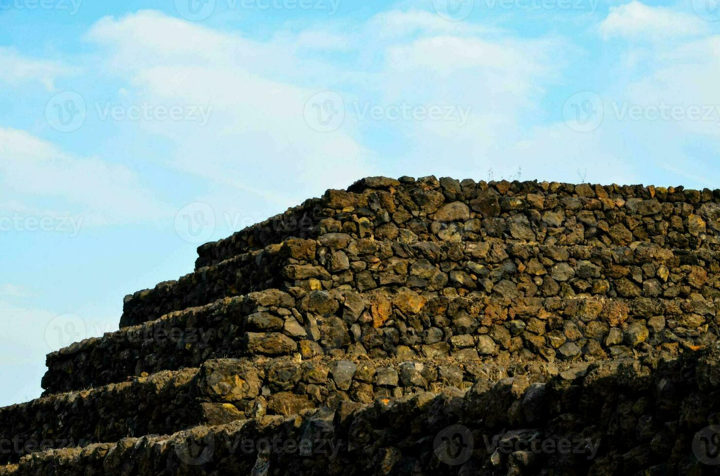 a stone wall with a blue sky in the background photo