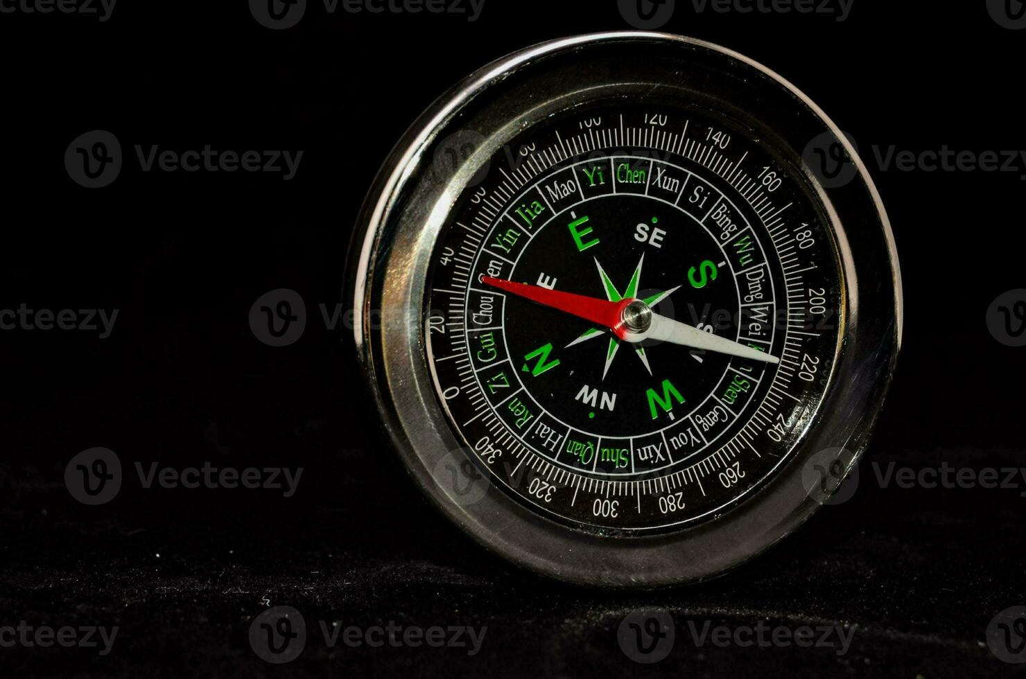 a black and silver compass on a black background photo