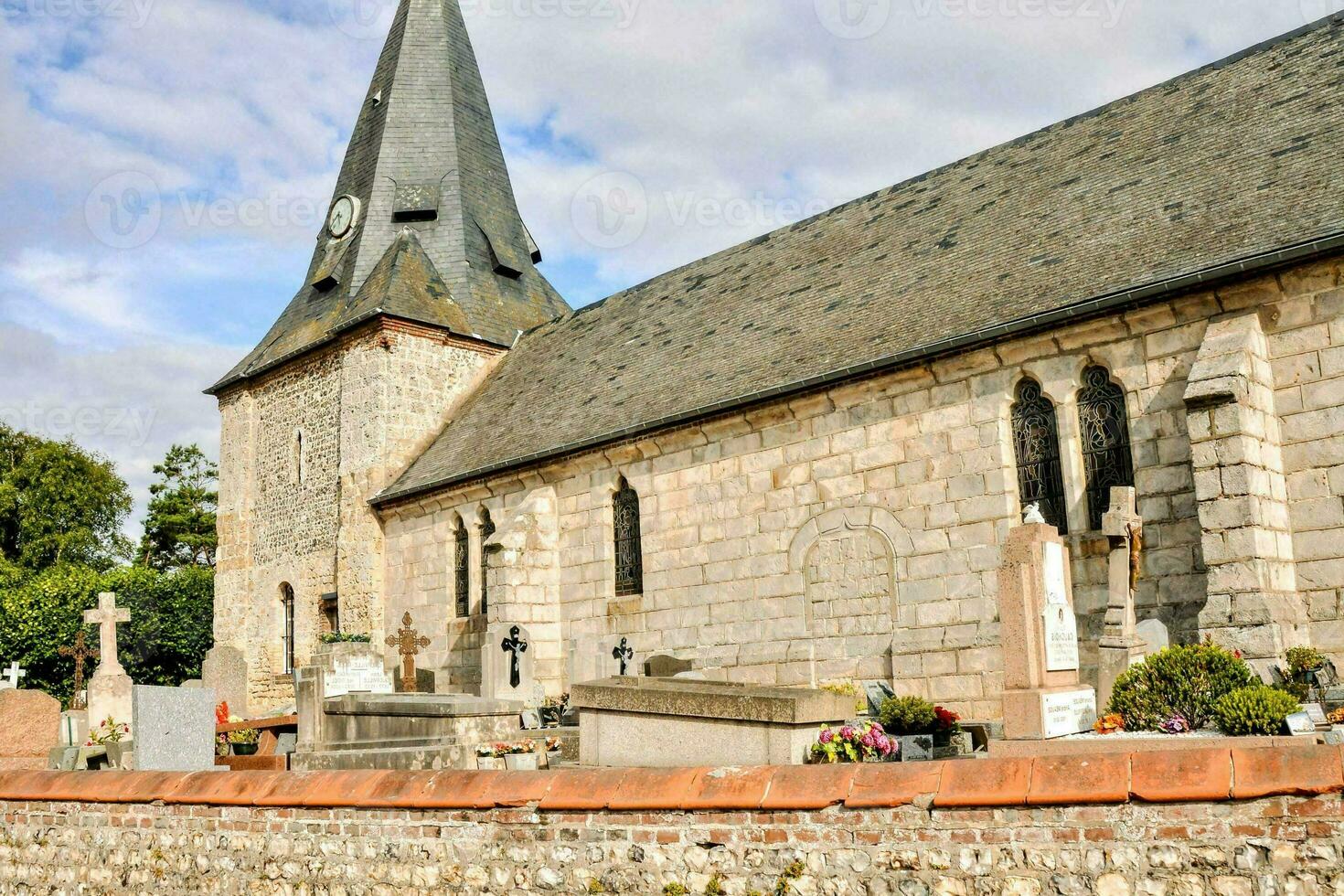 un Iglesia con un campanario y un Roca pared foto