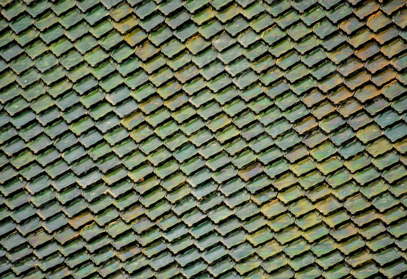 a close up of a green and yellow tile wall photo