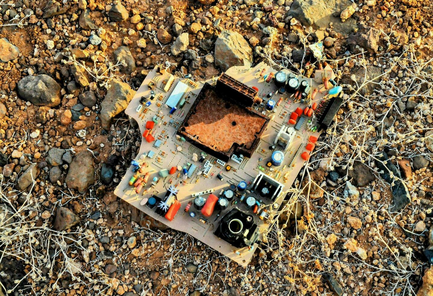 a broken computer on the ground in the desert photo