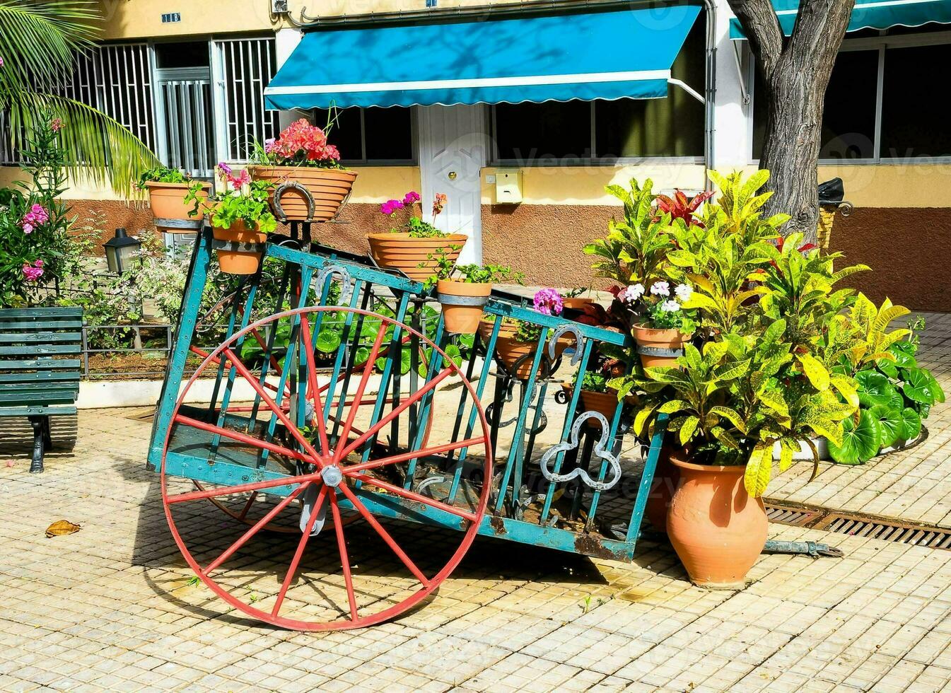 a cart with potted plants on it sitting on a brick sidewalk photo