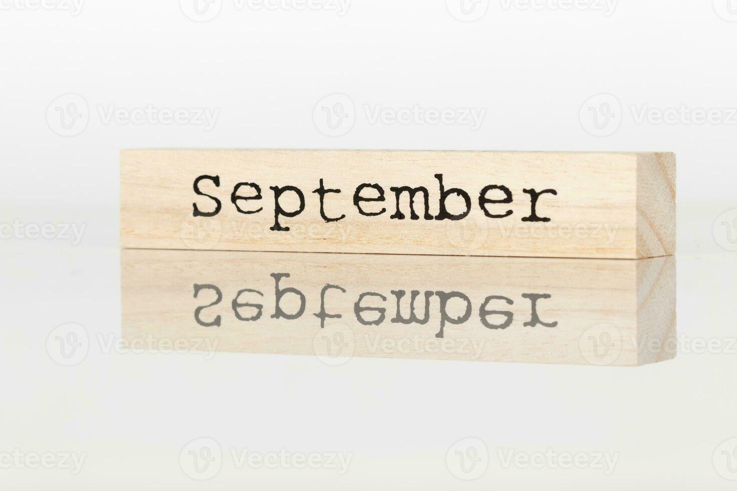 wooden cube with the inscription September on a white background photo