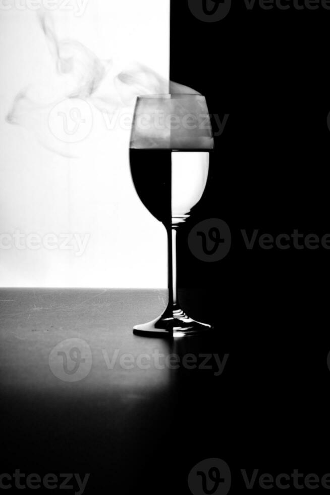 a glass of water and smoke on a black and white background photo