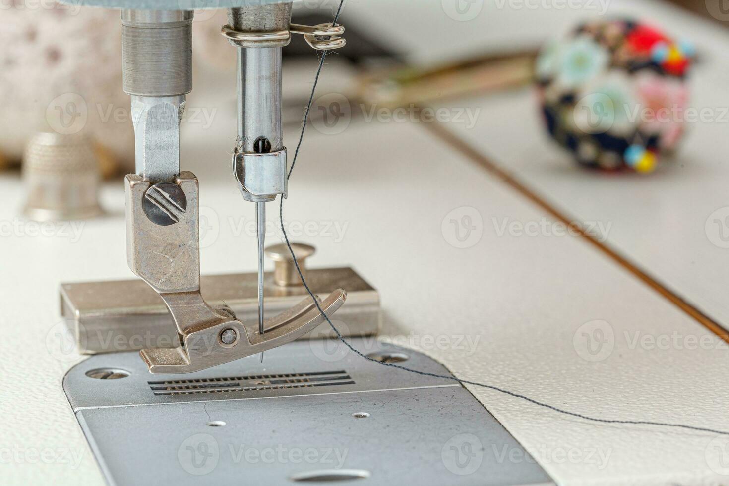 Sewing machine needle with thread and fabric photo