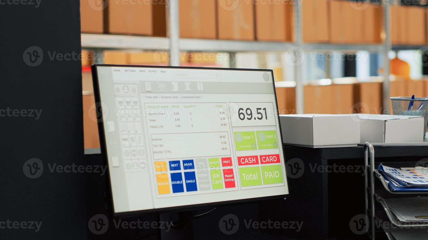 Computer with cash register in empty storage room, multiple cardboard boxes on racks and depot shelves. Warehouse with merchandise and retail products, packed stock goods in containers. photo