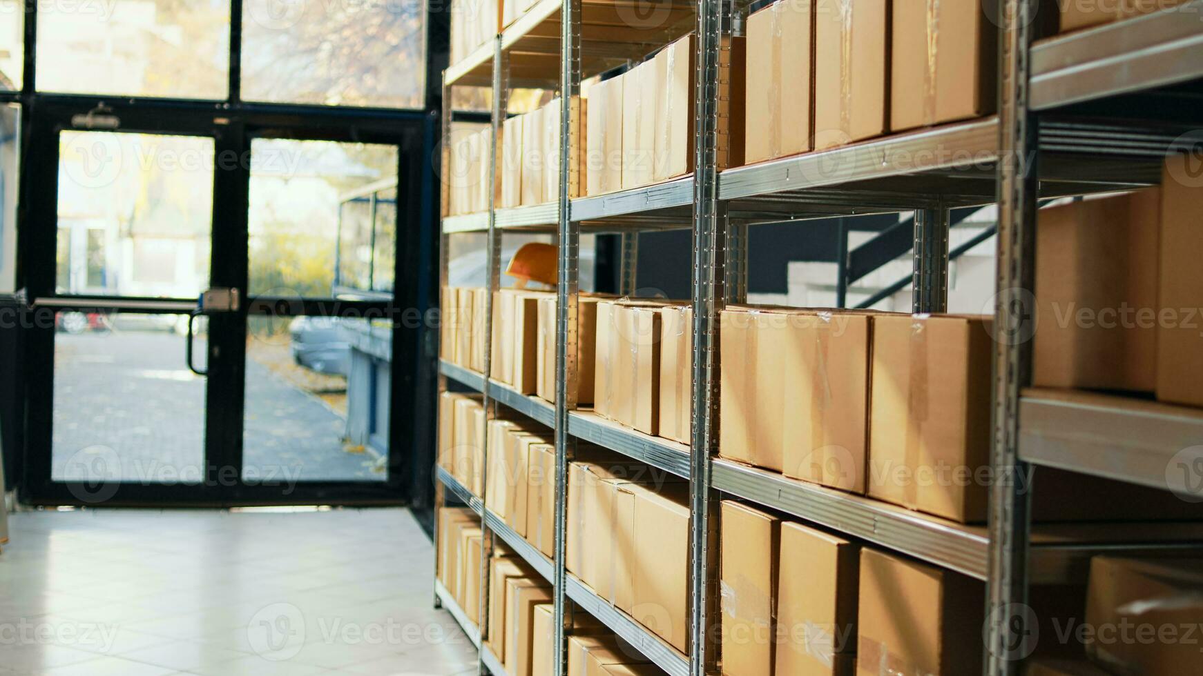 Empty storage room with packages on depot racks, containers and carton boxes prepared for stock distribution and order shipment. Warehouse space with retail store merchandise. photo