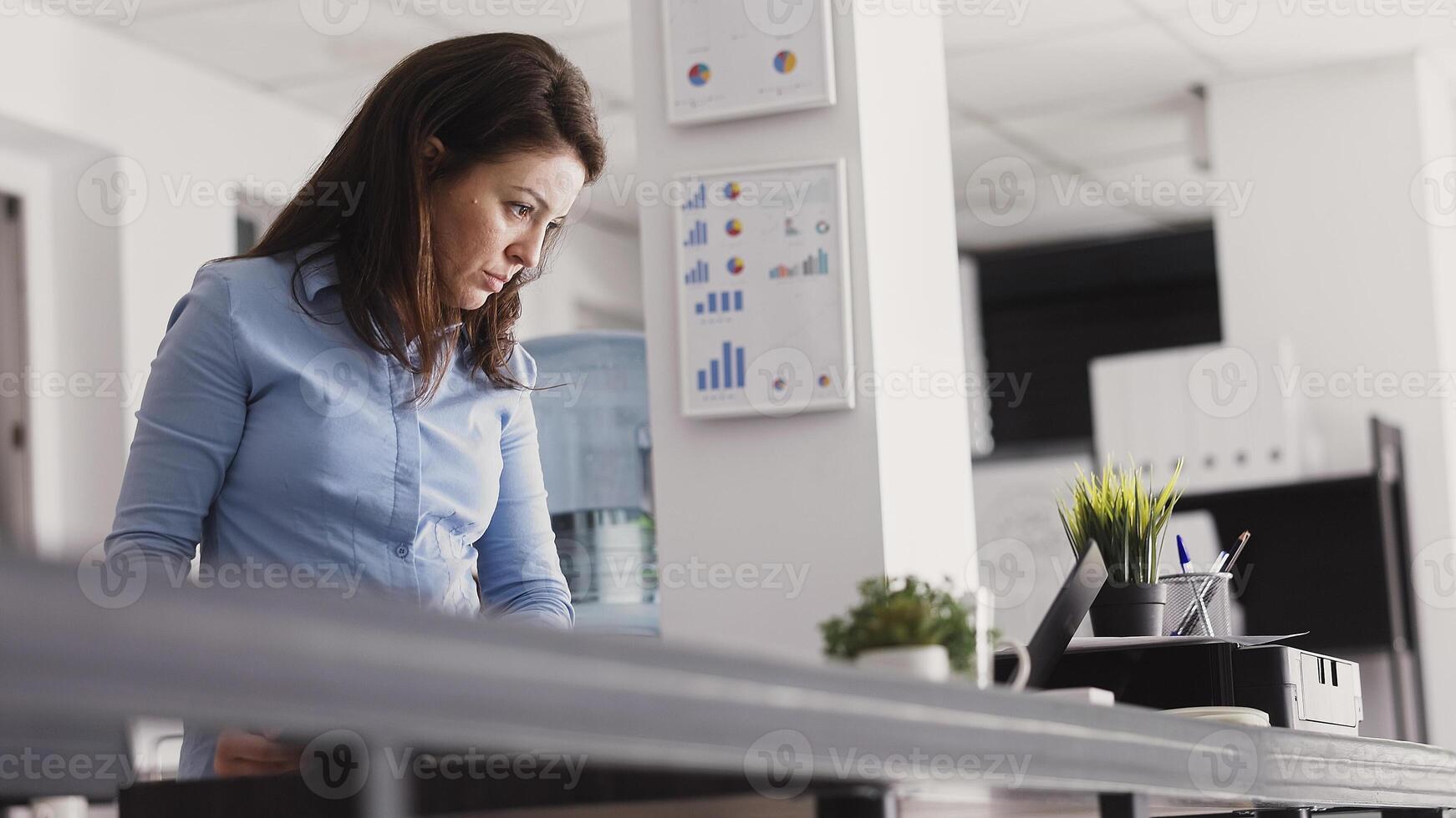 Corporate employee taking notes on clipboard papers and analyzing online report on pc. Executive manager looking at analytics on files to work on business investment and vision. Handheld shot. photo