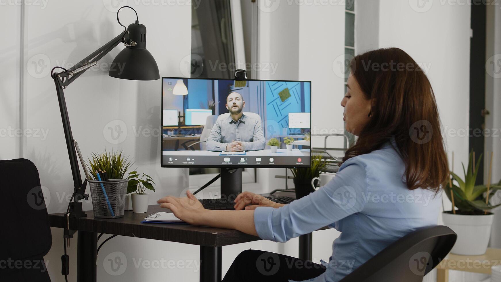 Young adult attending business meeting videocall, talking to manager about marketing vision in office. Female worker using remote videoconference call in coworking space, startup agency. photo