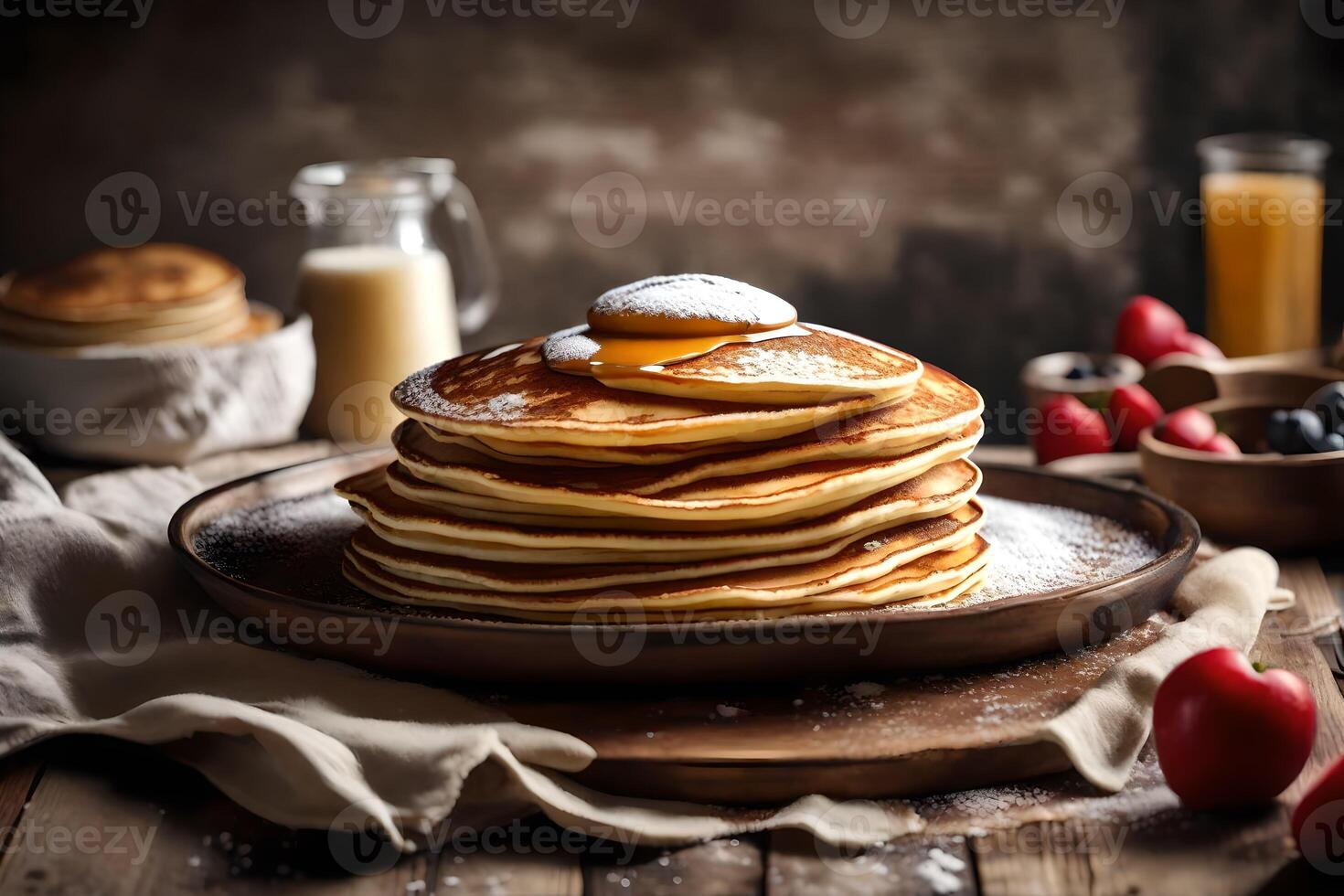Stack of pancakes with syrup and berries on a wooden table photo