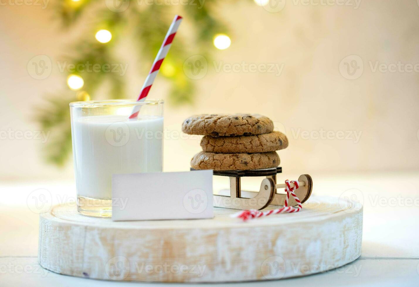 Nice Christmas tradition milk for Santa. Milk, cookies on Santa's sleigh, empty note on wooden stand photo