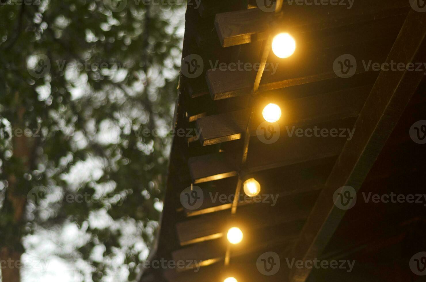 un fila de ardiente retro ligero bombillas decorando un de madera estructura foto