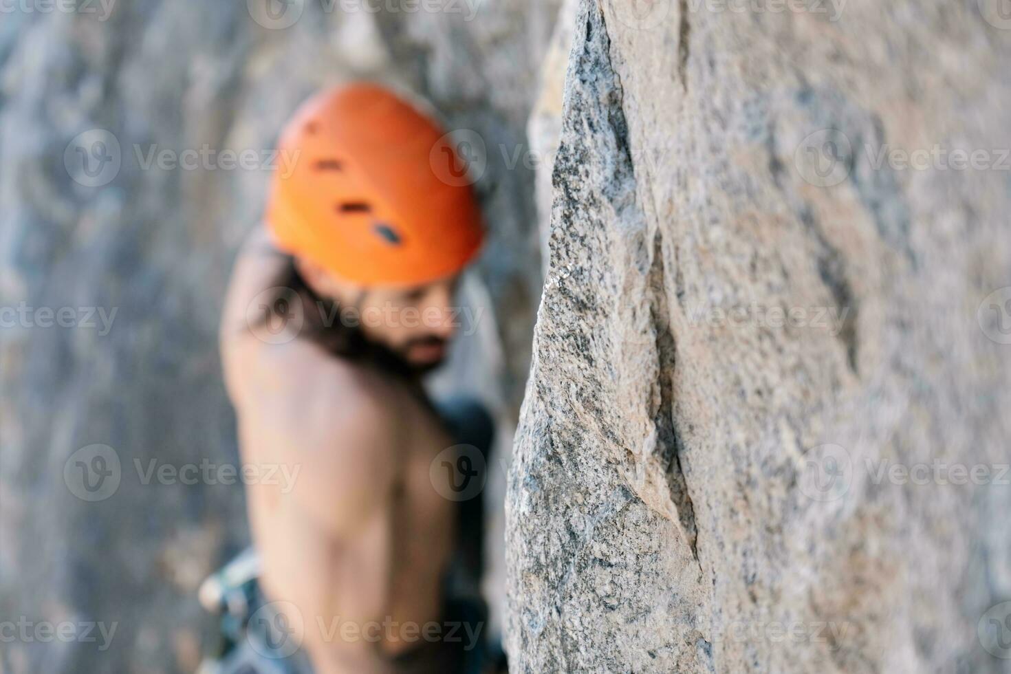 Male rock climber selective focus on rock. photo