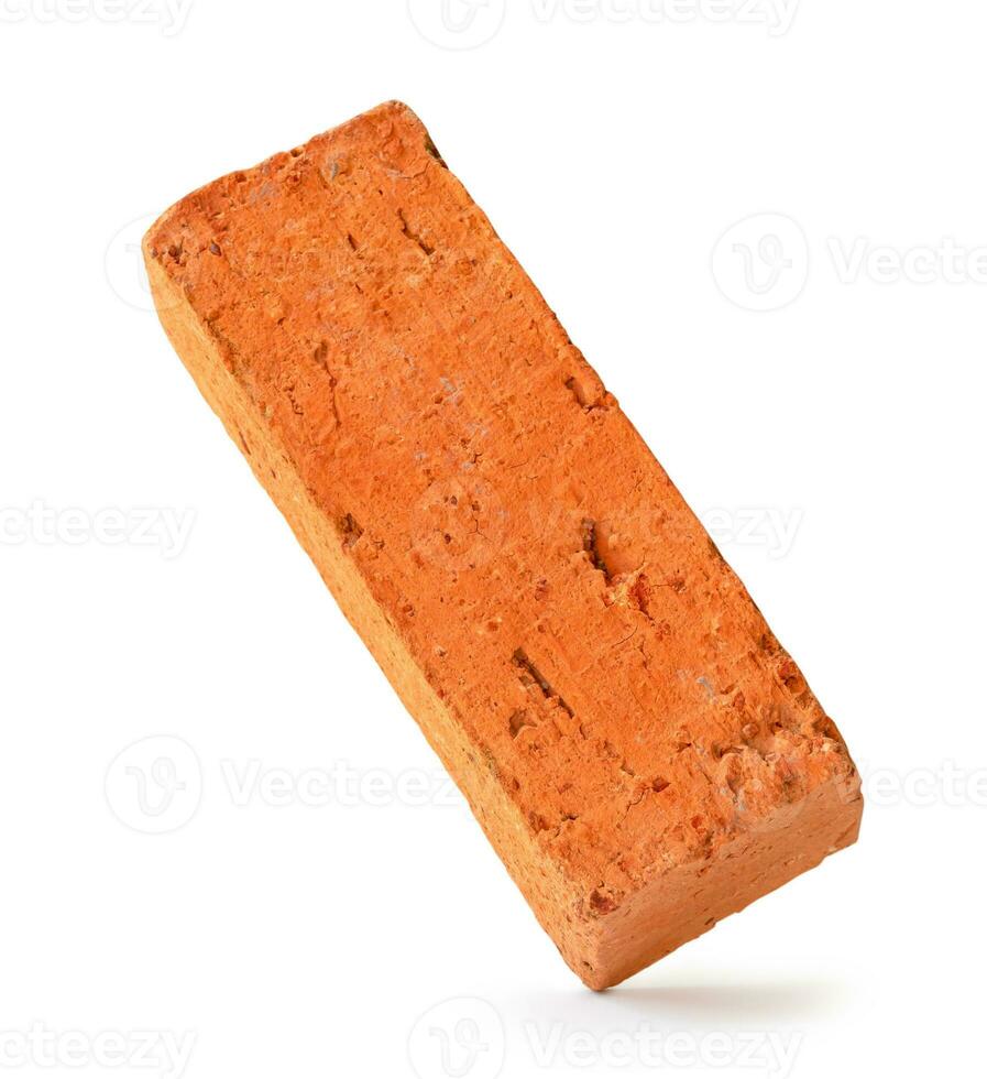 Single cracked old red or orange brick isolated on white background with clipping path photo