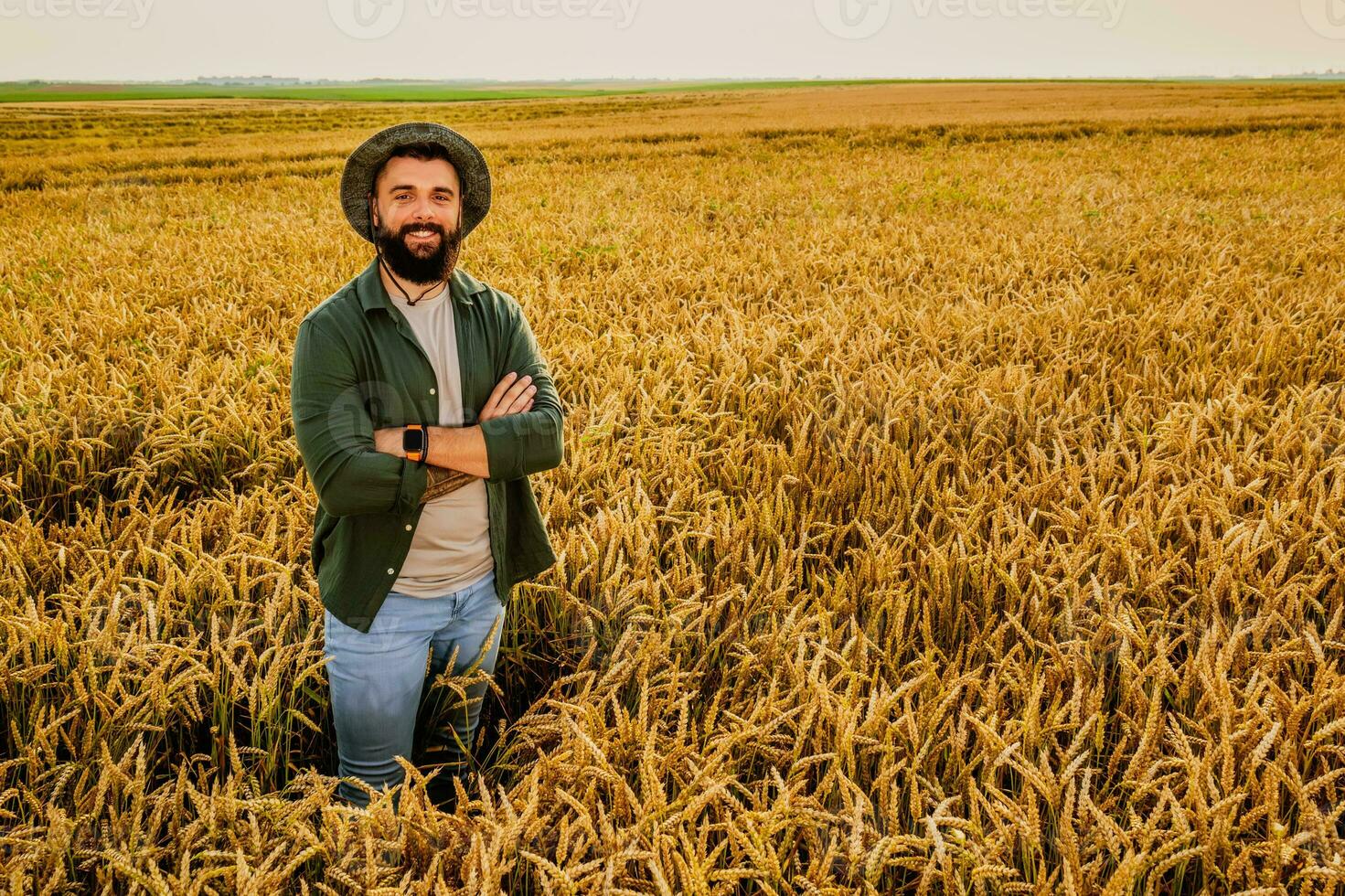 retrato de granjero quien es cultivando trigo. él es satisfecho con bueno Progreso de plantas. agrícola ocupación. foto