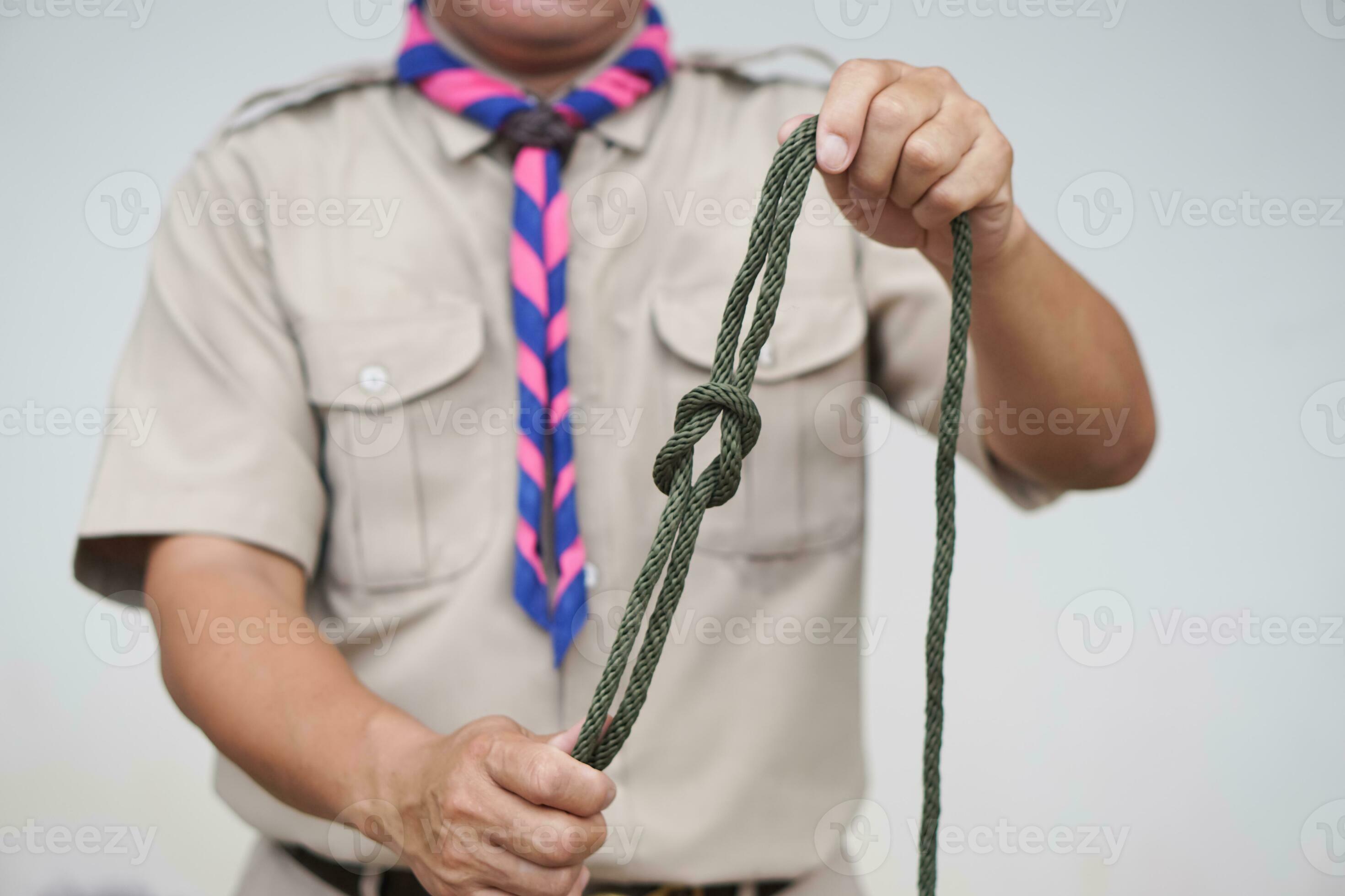 Tying rope knot pattern, demonstrated by scout teacher trainer. Concept