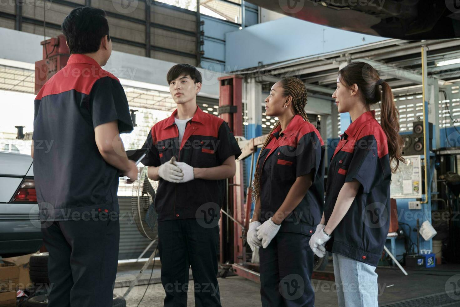 masculino experto supervisor ingeniero tren y discutir con profesional mecánico trabajador equipos, inspeccionar reparar trabajo a coche Servicio cochera, armonioso grupo, y hacer mantenimiento trabajos en automotor industria. foto