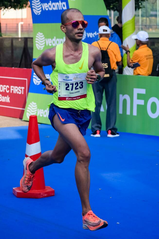 nuevo Delhi, India - julio dieciséis 2023 - vedanta Delhi medio maratón carrera después codicioso en cuales maratón Participantes acerca de a cruzar el terminar línea, Delhi medio maratón 2022 foto