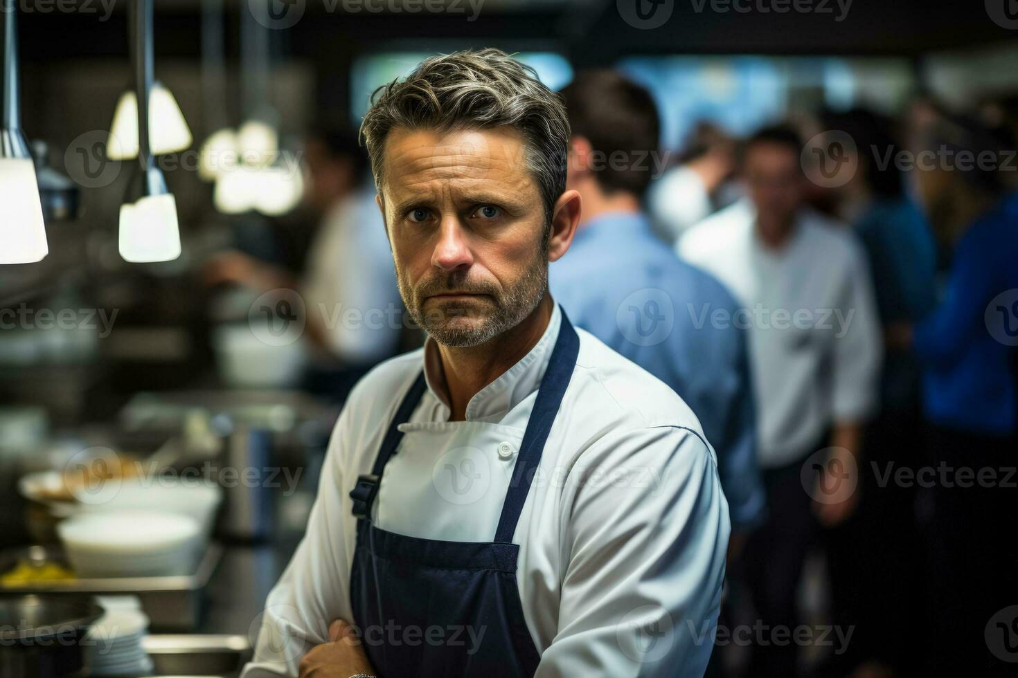 Chef somberly contemplates amidst the chaos of a busy professional kitchen photo