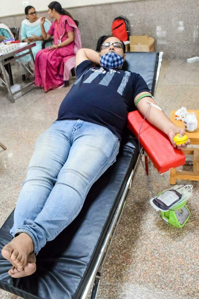 Delhi, India, July 19 2023 - Blood donor at Blood donation camp held at Balaji Temple, Vivek Vihar, Delhi, India, Image for World blood donor day on June 14 every year, Blood Donation Camp at Temple photo