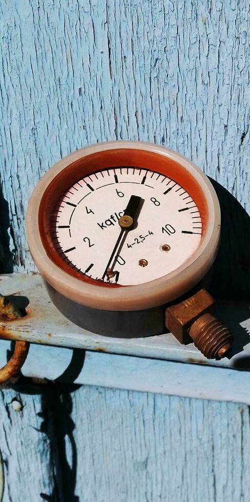 Old soviet pressure gauge in a carbolite case on a wooden background photo