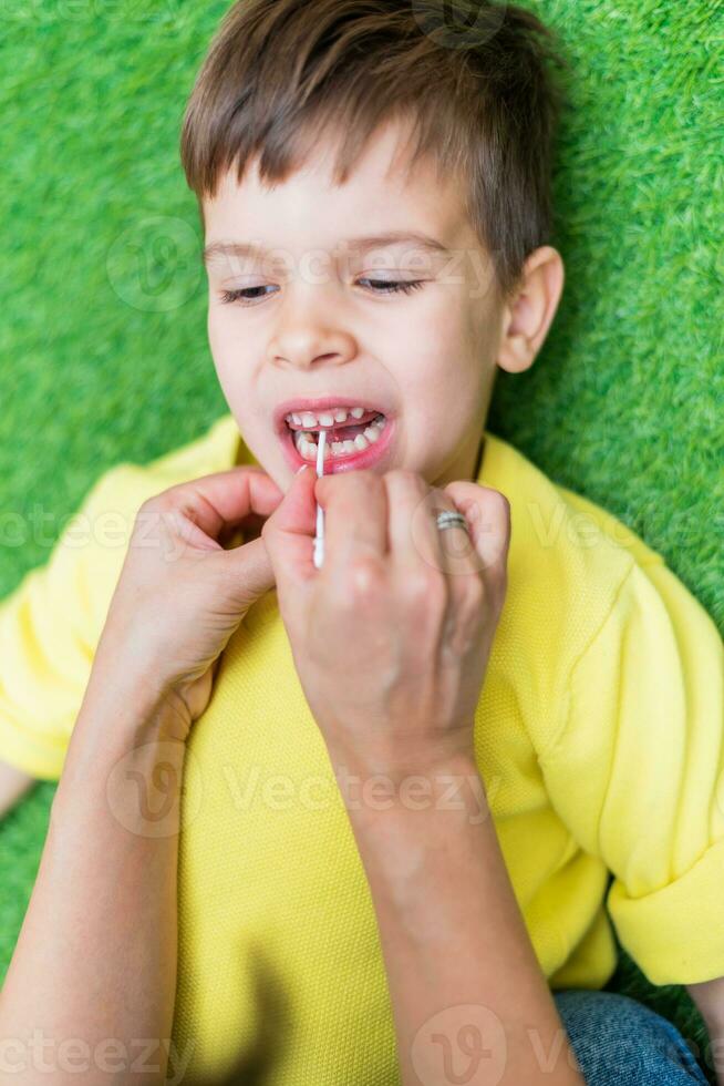 Woman speech therapist helps a child correct the violation of his speech in her office photo