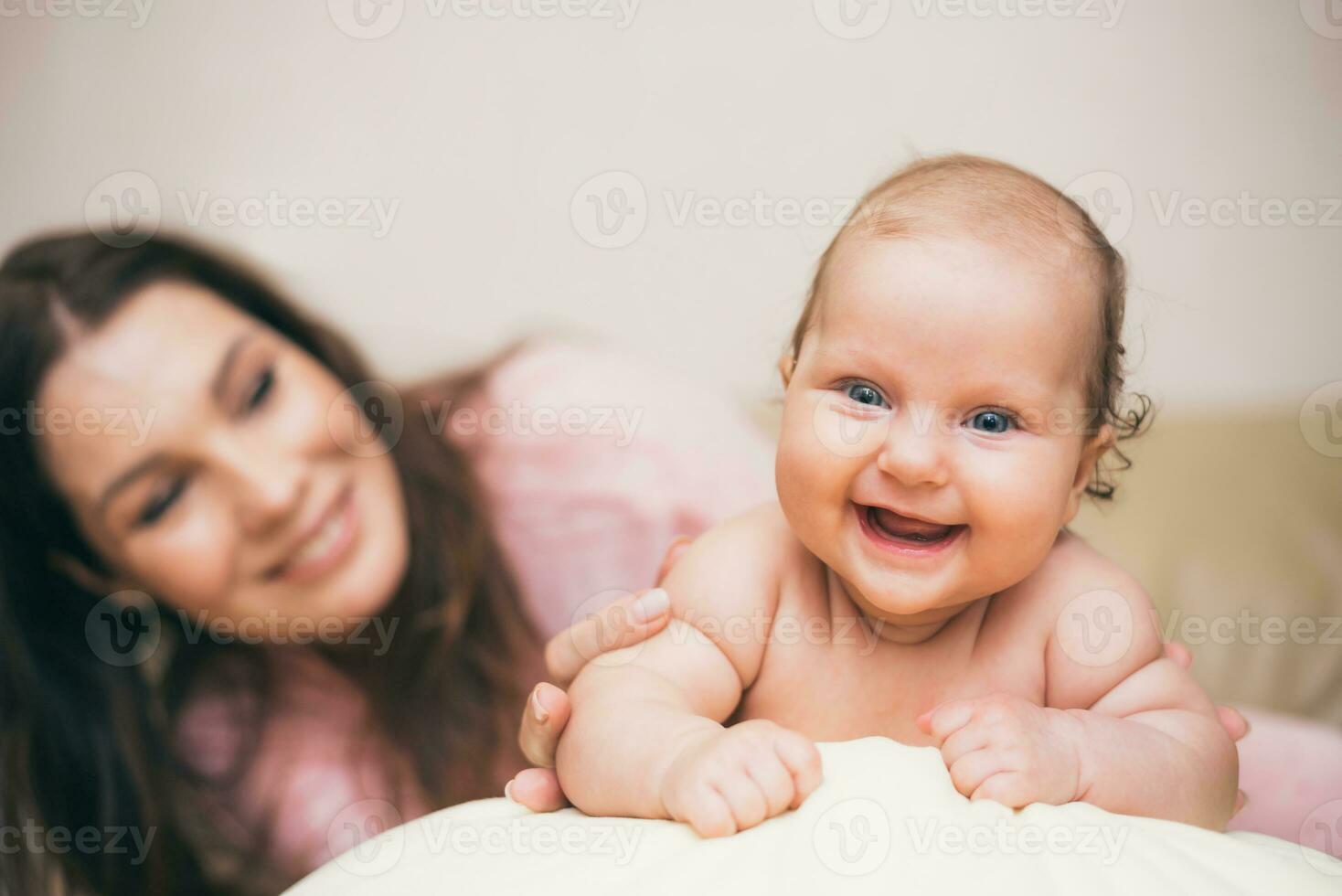 contento mamá con su riendo bebé jugando en el habitación foto