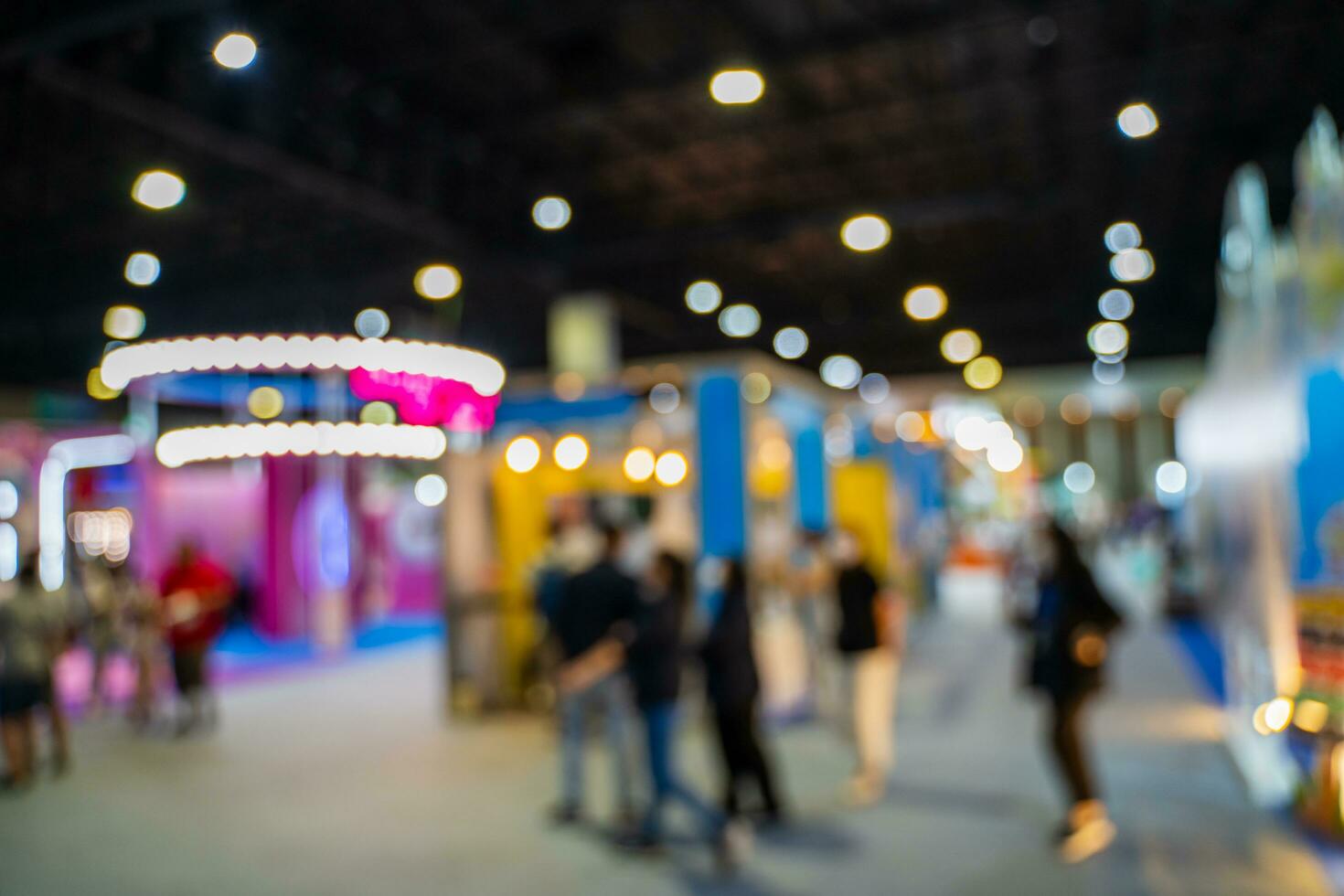Blurred images of trade fairs in the big hall. image of people walking on a trade fair exhibition or expo where business people show innovation activity and present products in a big hall. photo