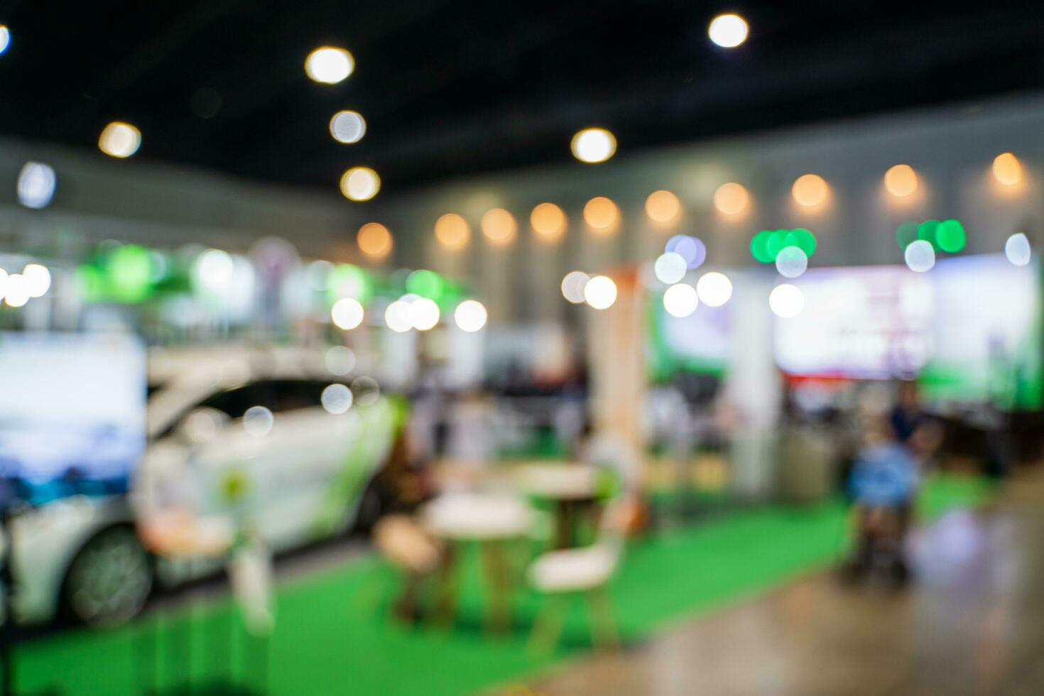 Blurred images of trade fairs in the big hall. image of people walking on a trade fair exhibition or expo where business people show innovation activity and present products in a big hall. photo